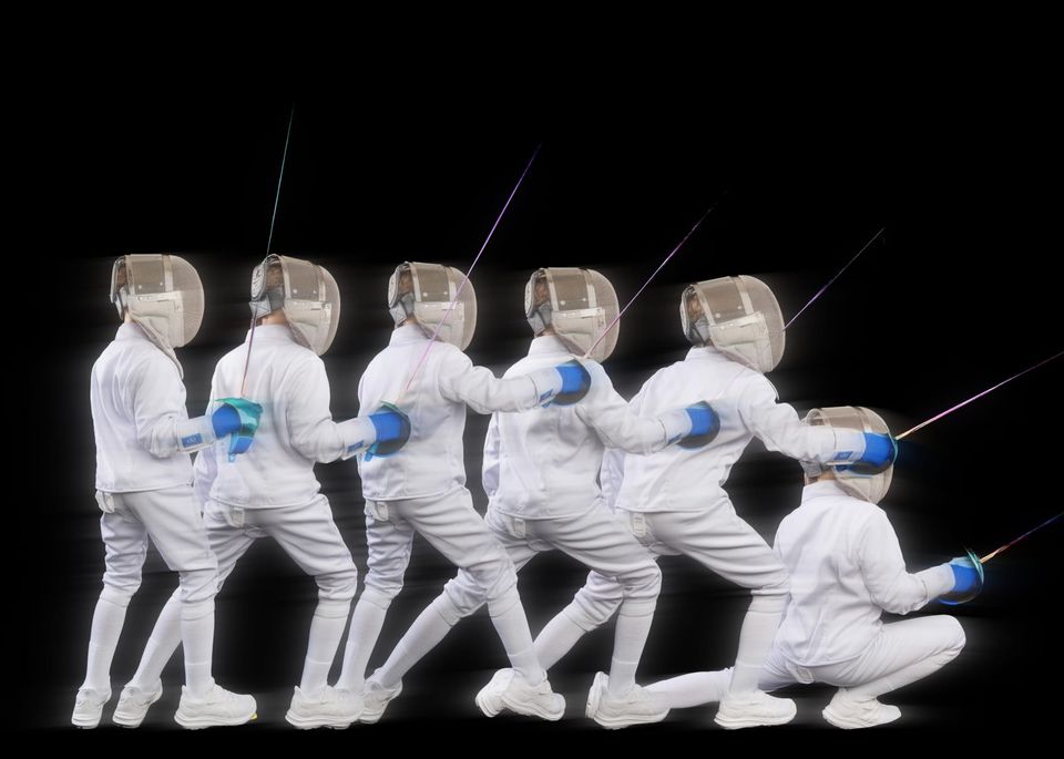 One fencer in white kit and mask, shown again and again in a single picture, steps forward and drops into a deep lunge, blade forward